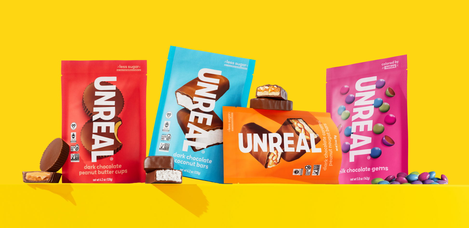 Front view of Unreal Gift Box showcasing four chocolate varieties with a bright yellow background