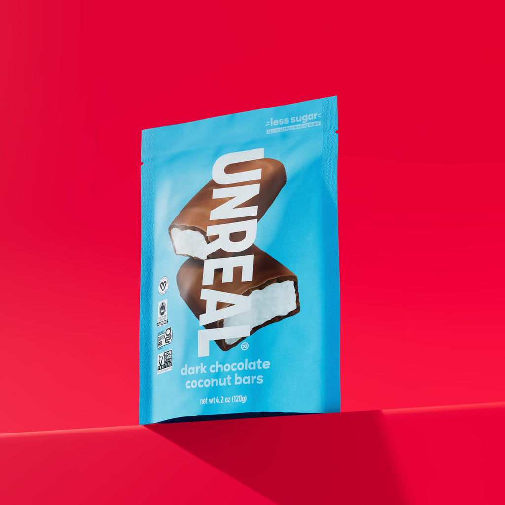 UNREAL dark chocolate coconut bars package with two chocolate-covered bars on a red background