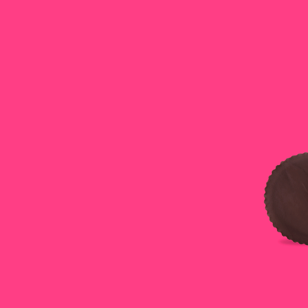 Chocolate peanut butter cup on bright pink background