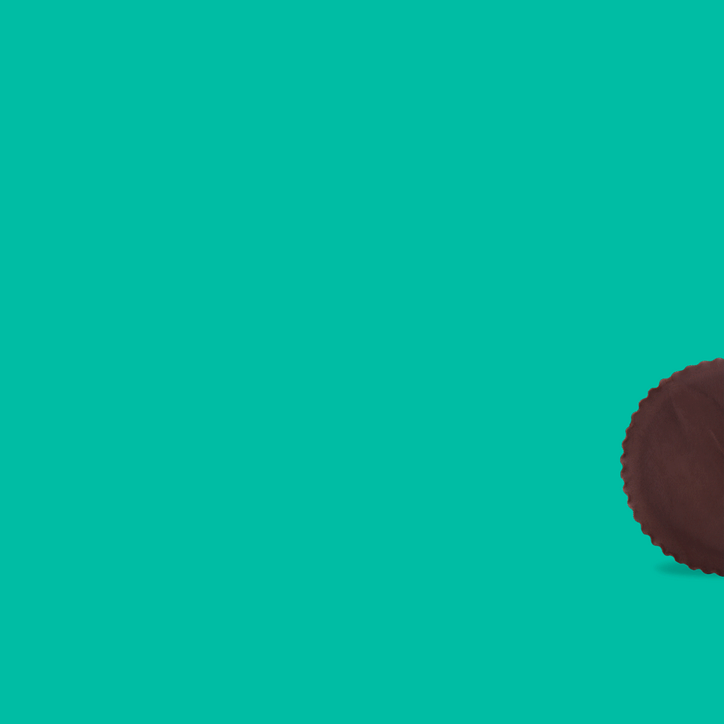 Partial view of a chocolate-covered peanut butter cup on a teal background