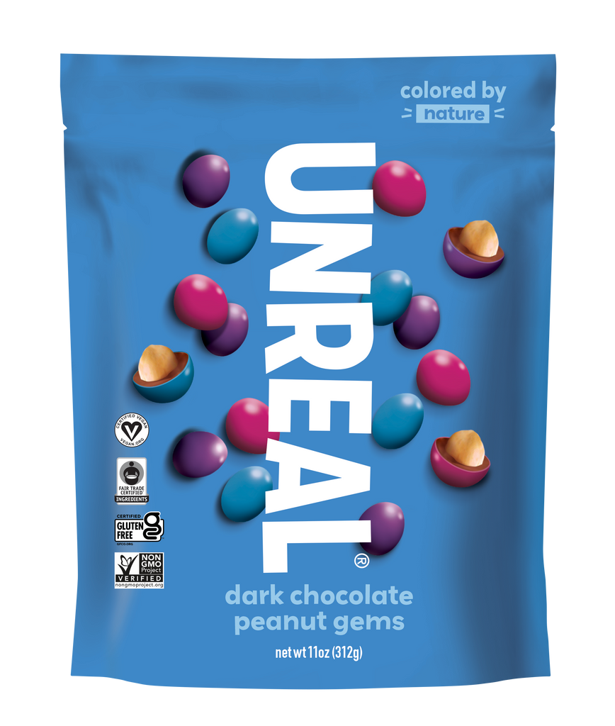 Front of UNREAL dark chocolate peanut gems with large UNREAL logo and candy-coated pieces, some halved to reveal peanuts